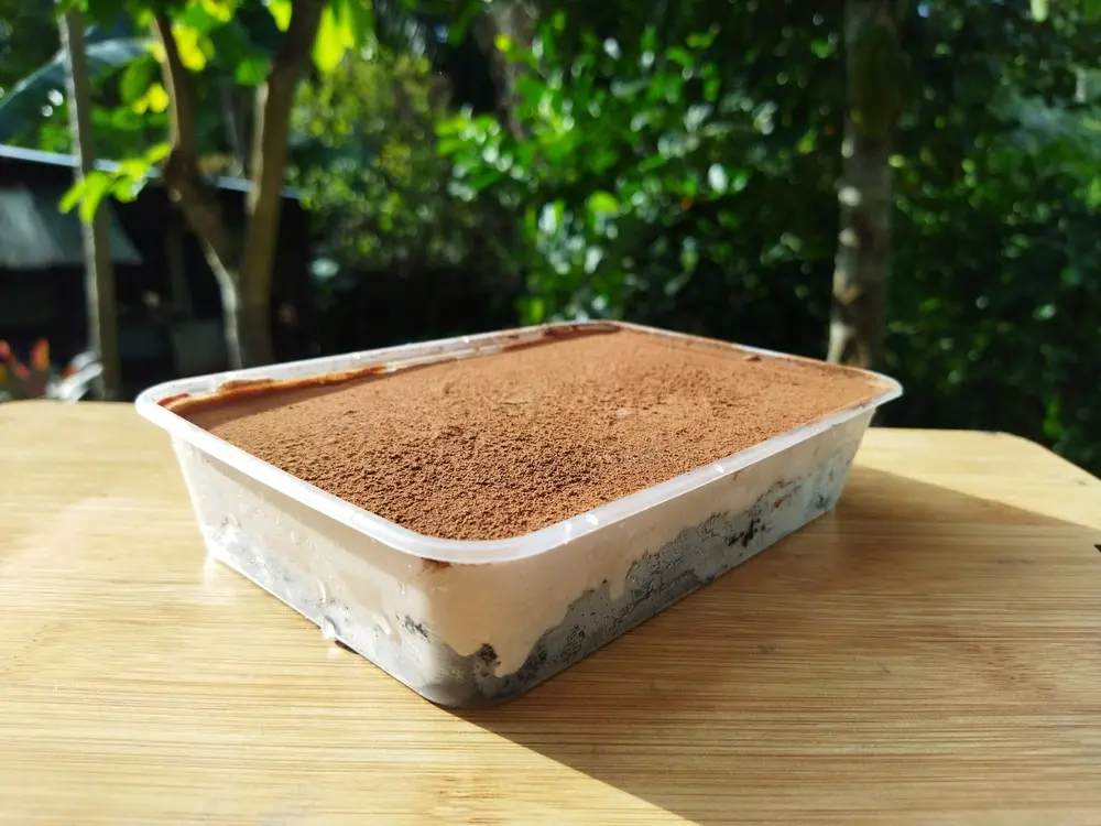 Dream Cake dessert in a rectangular tub with cocoa topping